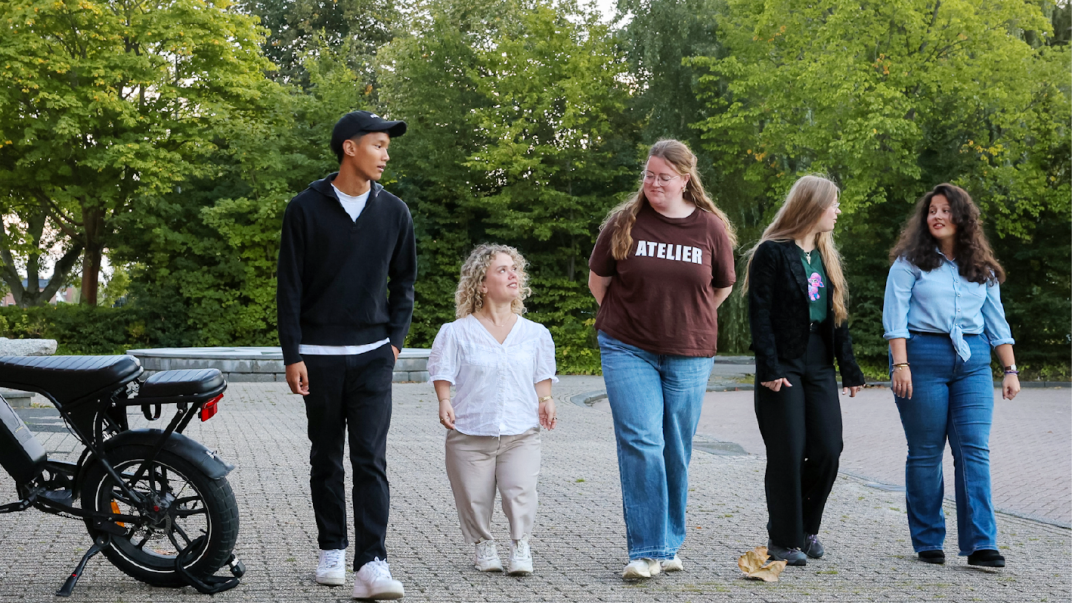 4 jongeren lopen naast elkaar en kijken elkaar aan, links staat een fatbike. Onderaan staat de tekst: "Bijna 18? En nu? Geldwijzereemsdelta.nl". Met de kleuren oranje, wit en blauw. Rechts staat het kompas-logo van Geldwijzer Eemsdelta.